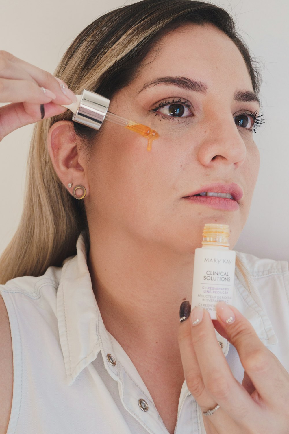 a woman is putting an orange substance on her face