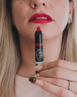 a woman holding a lipstick in her hand