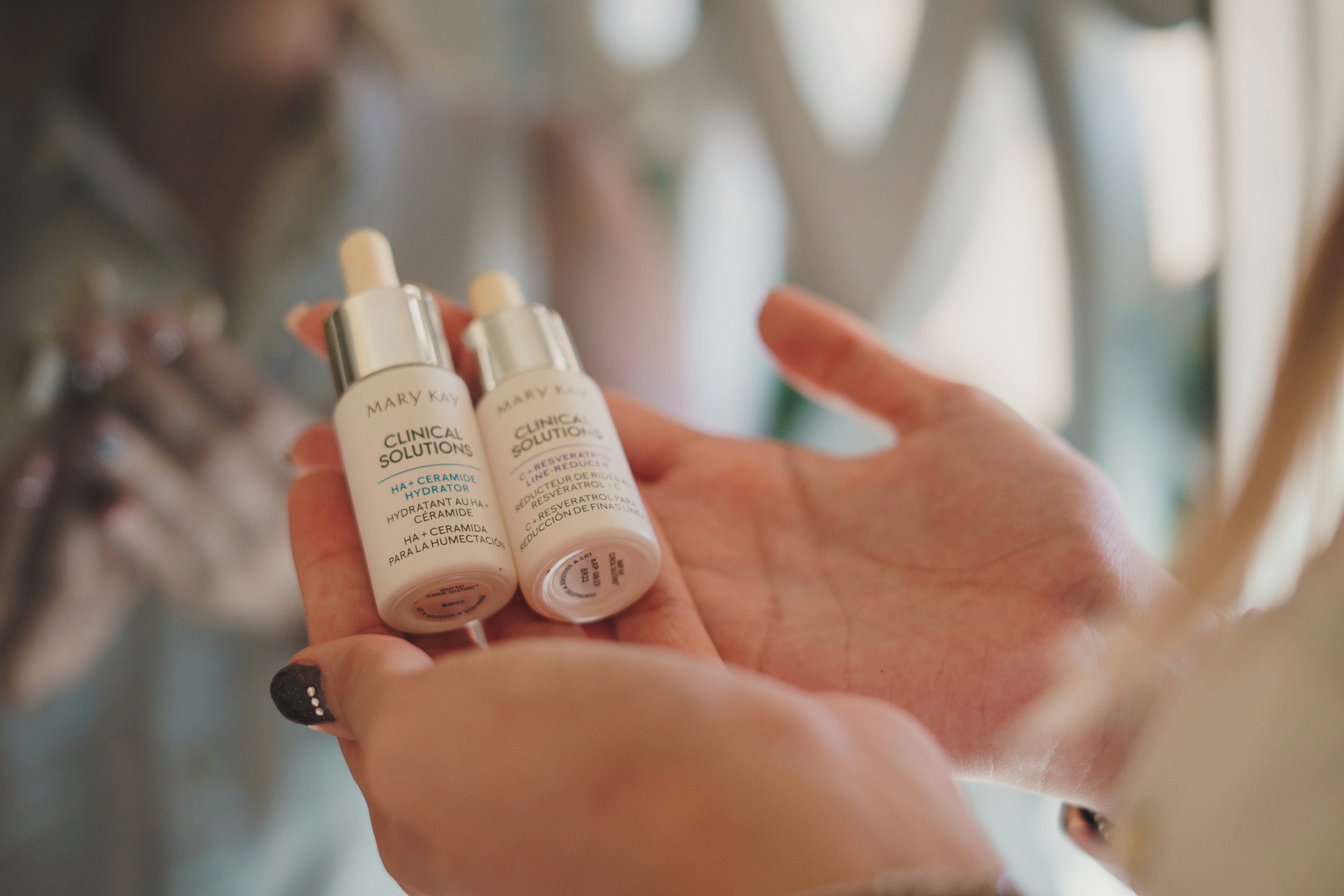 a woman holding two bottles of skin care products