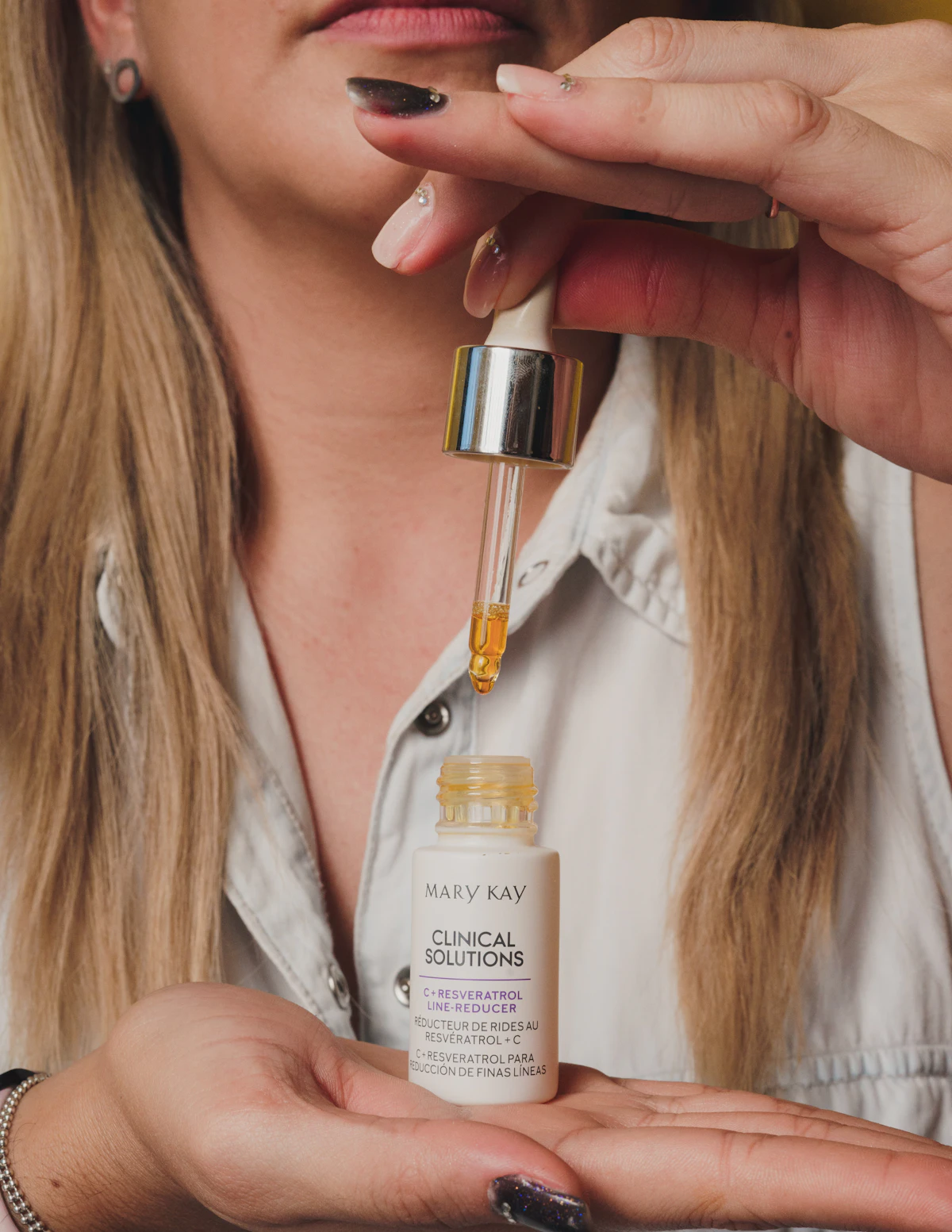 Woman holding a bottle of skin care serum