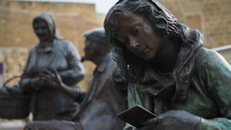 a statue of a woman reading a book
