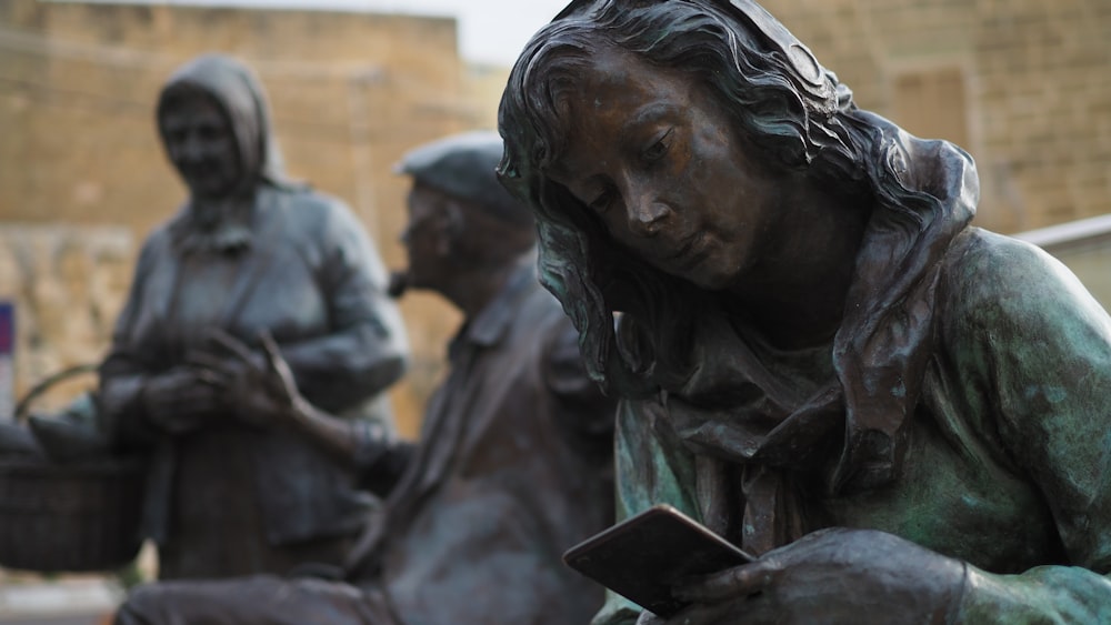 Una estatua de una mujer leyendo un libro