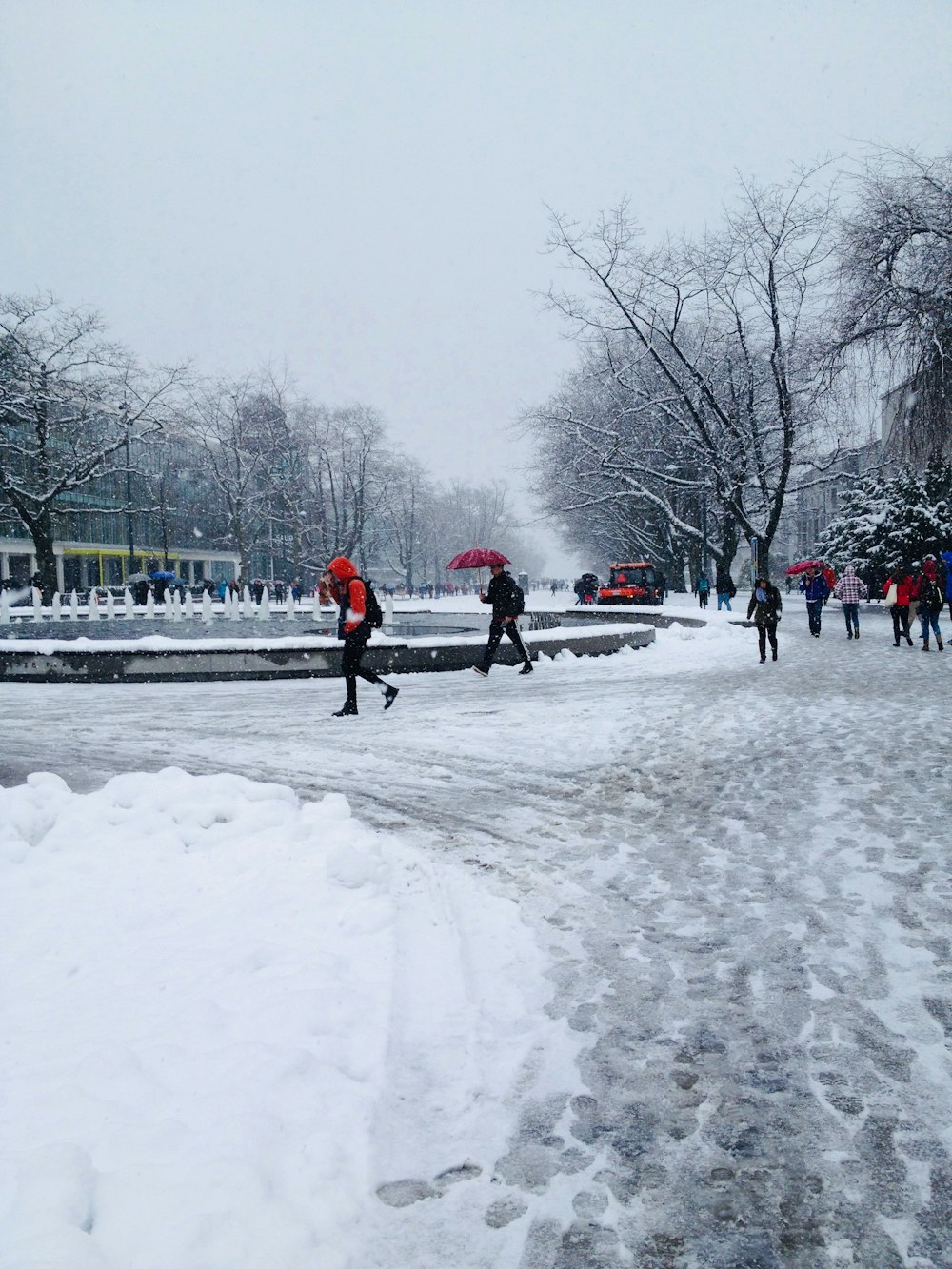 a group of people walking across a snow covered street