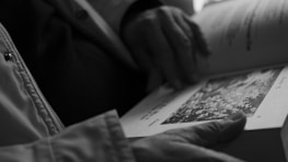 A close-up of hands holding an open book with vibrant illustrations.