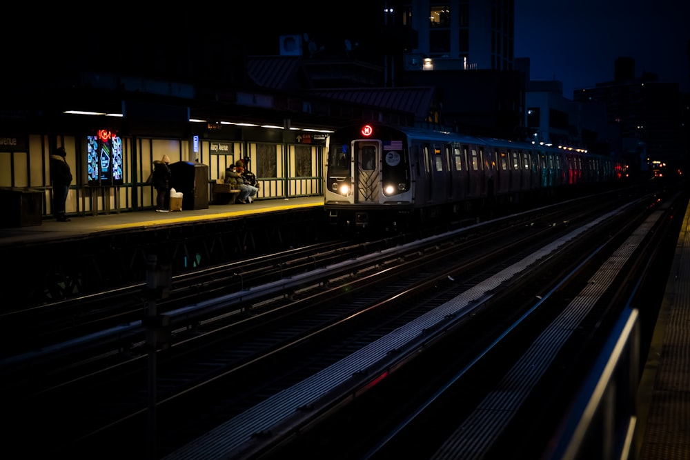 a train pulling into a train station at night