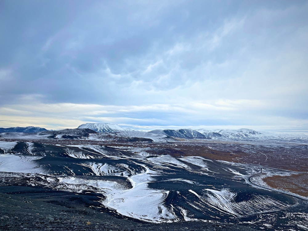 a snowy landscape with mountains in the distance