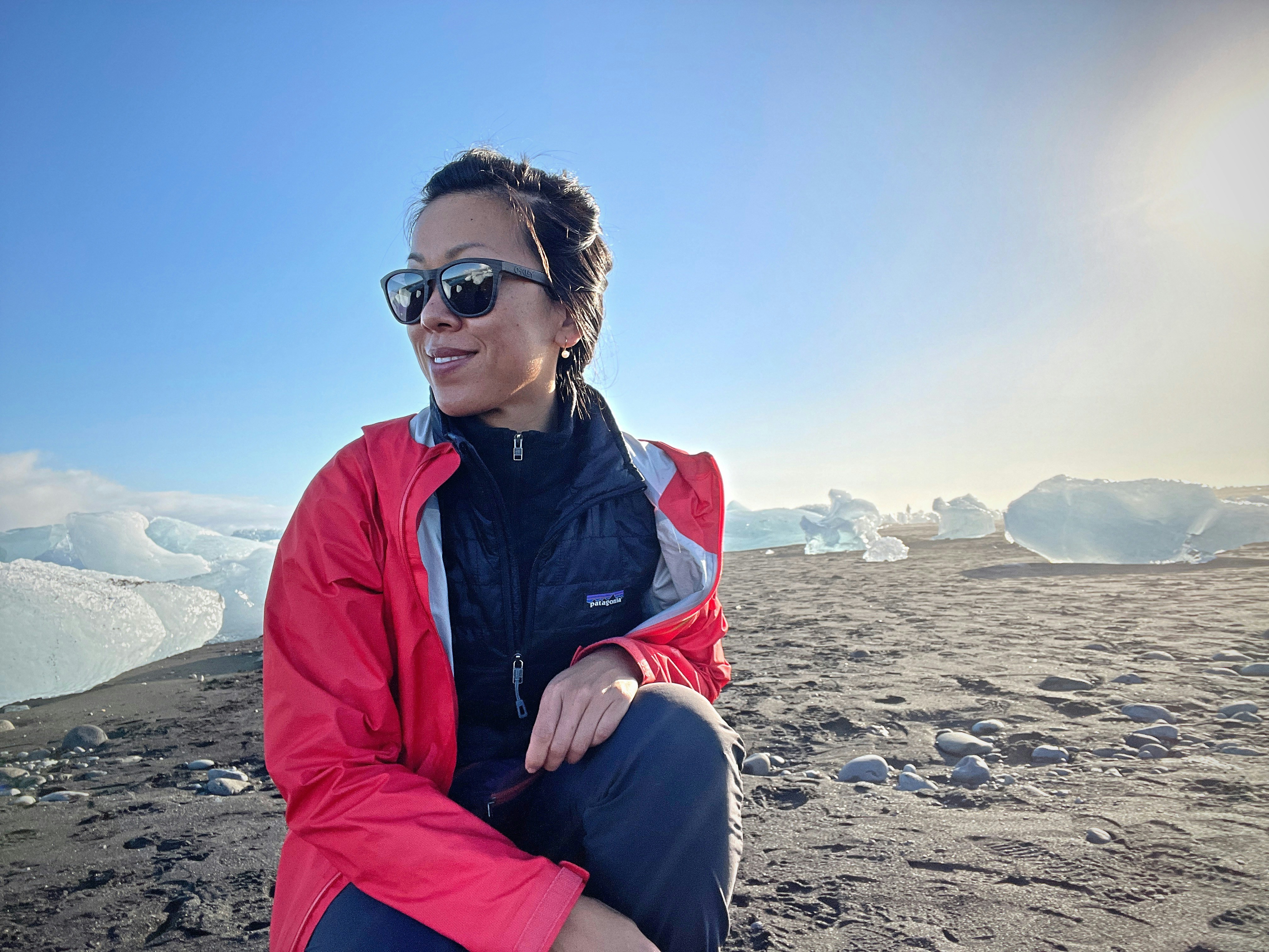 Une femme assise au sommet d’une plage de sable