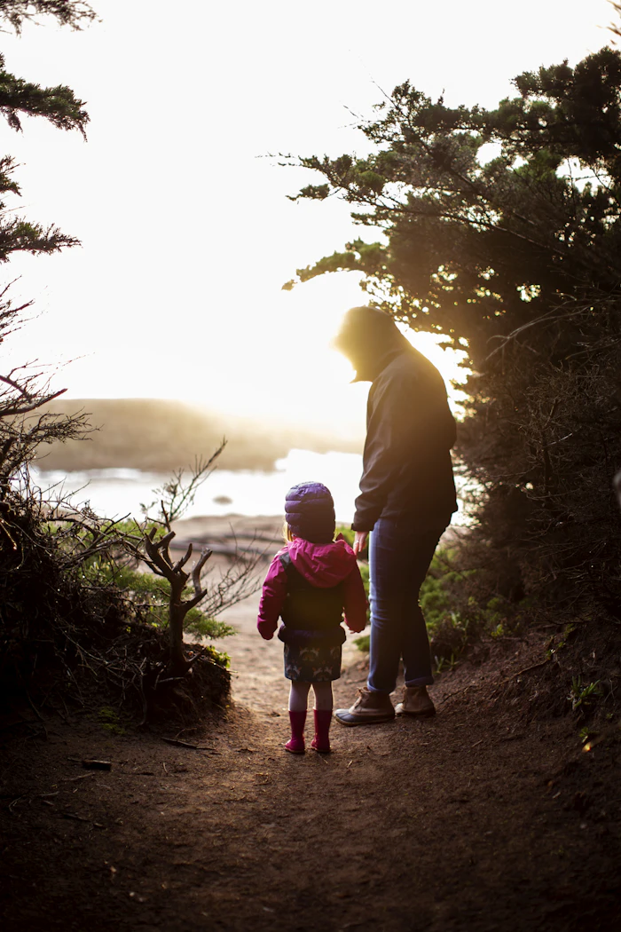 Parent and child walking at sunset