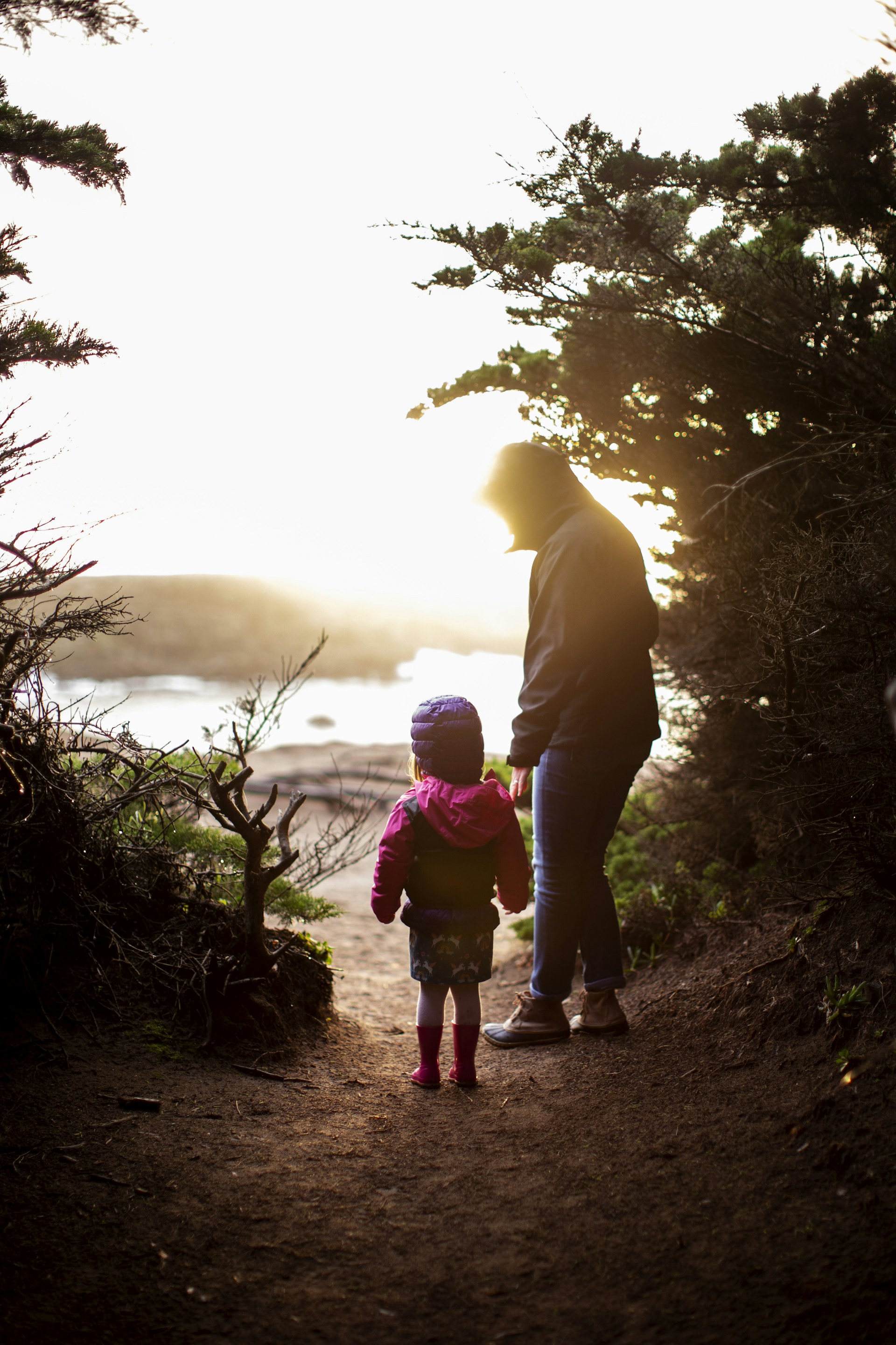 a man and a little girl walking down a path