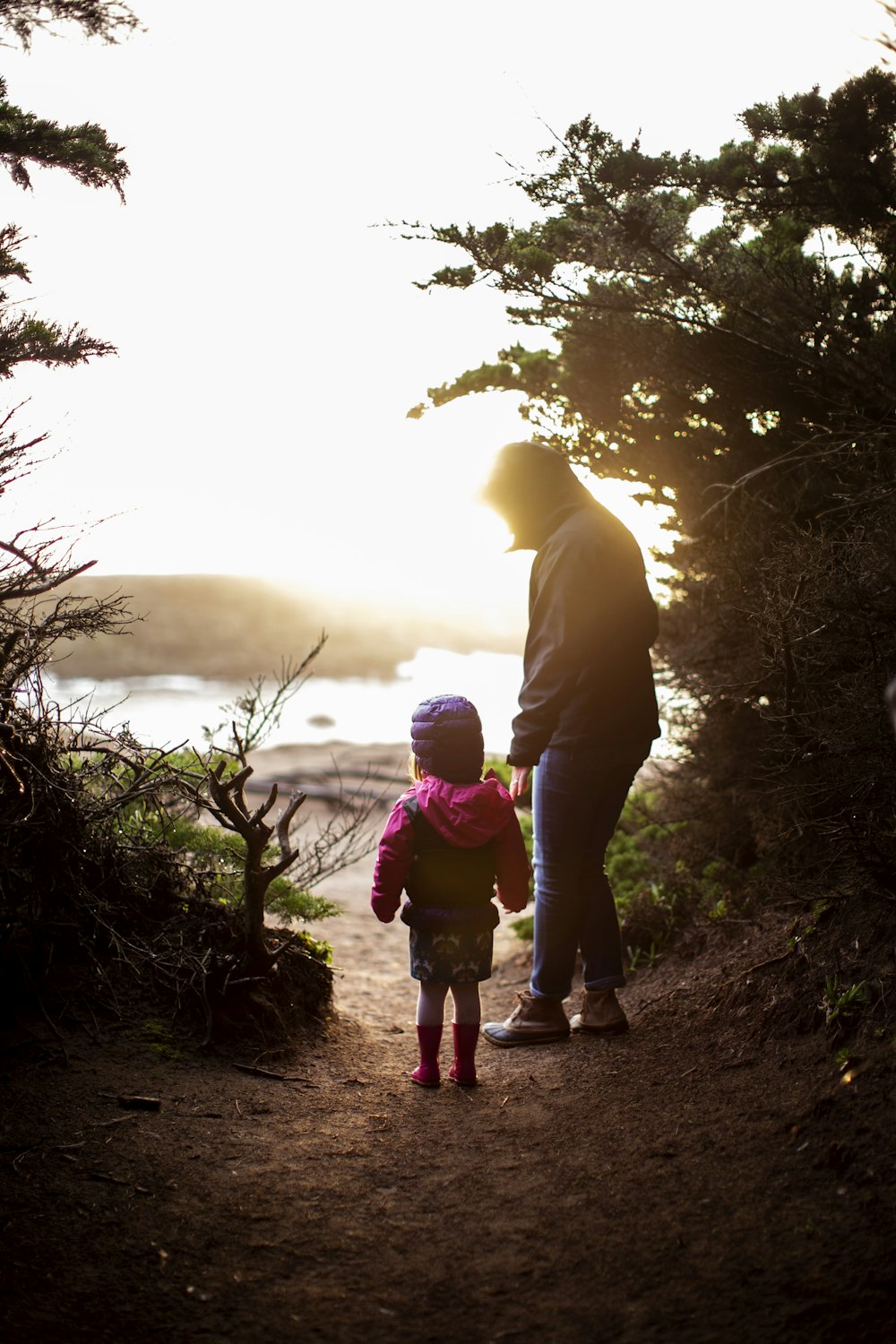 a man and a little girl walking down a path