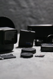 Camera accessories including straps, batteries, and cleaning kits displayed on a white background.
