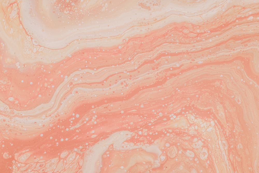 a close up of a pink and white marble surface