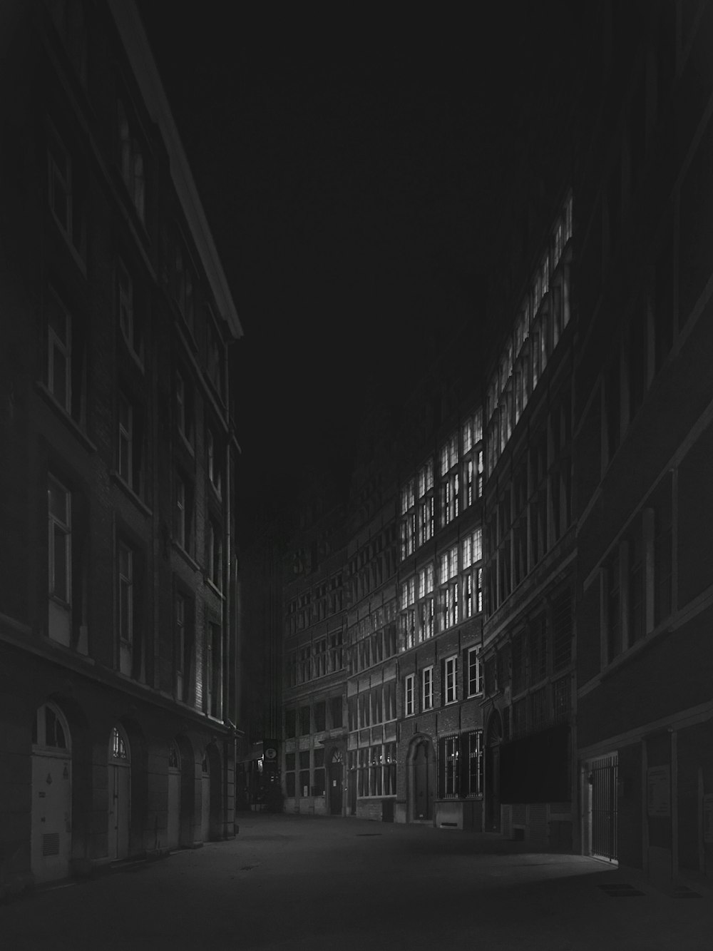 a black and white photo of a city street at night