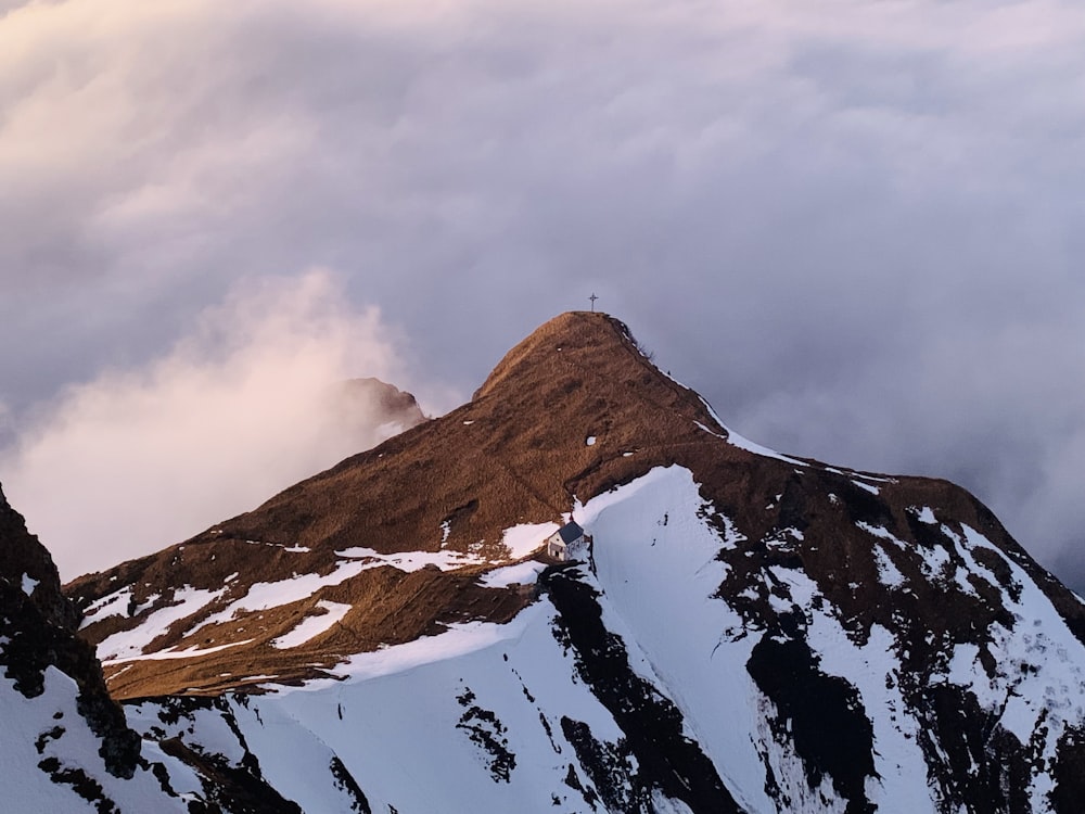 a snow covered mountain with clouds in the background