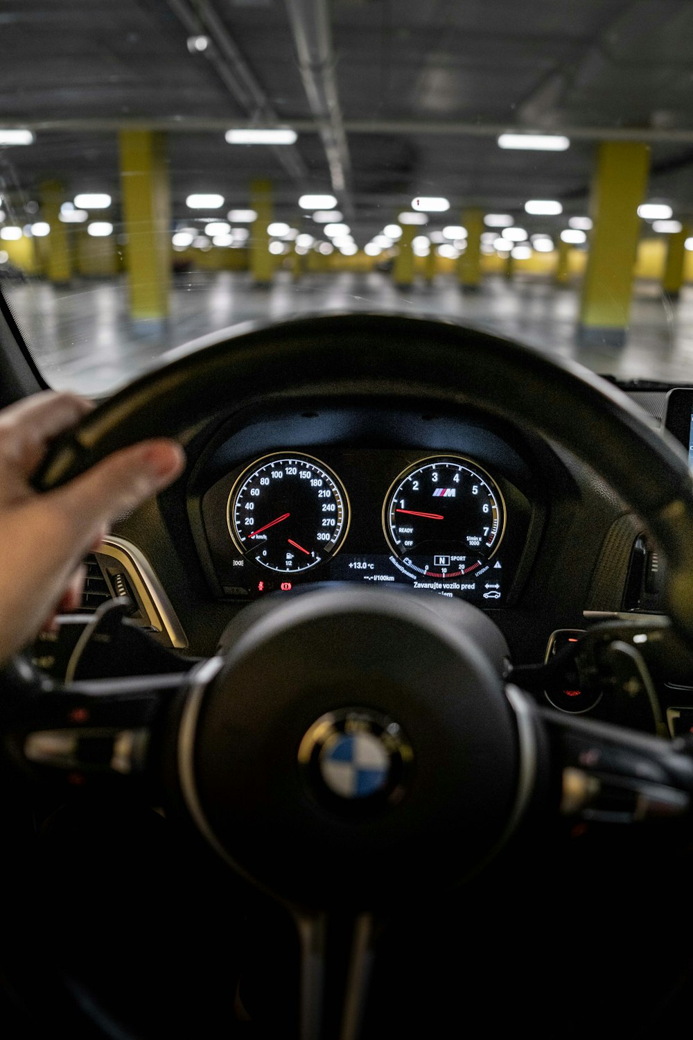 a person driving a car in a parking garage