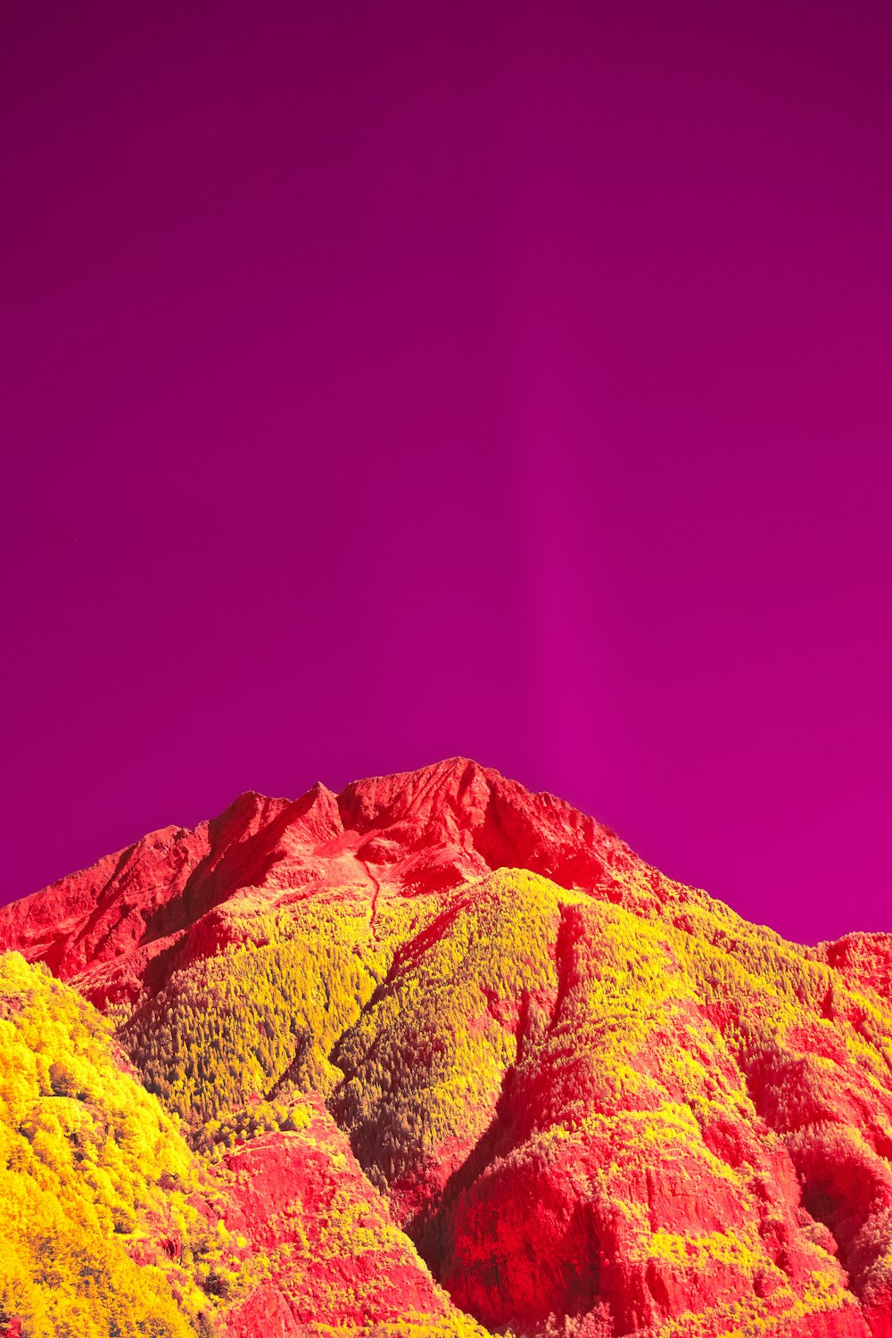a mountain covered in yellow and red colored rocks