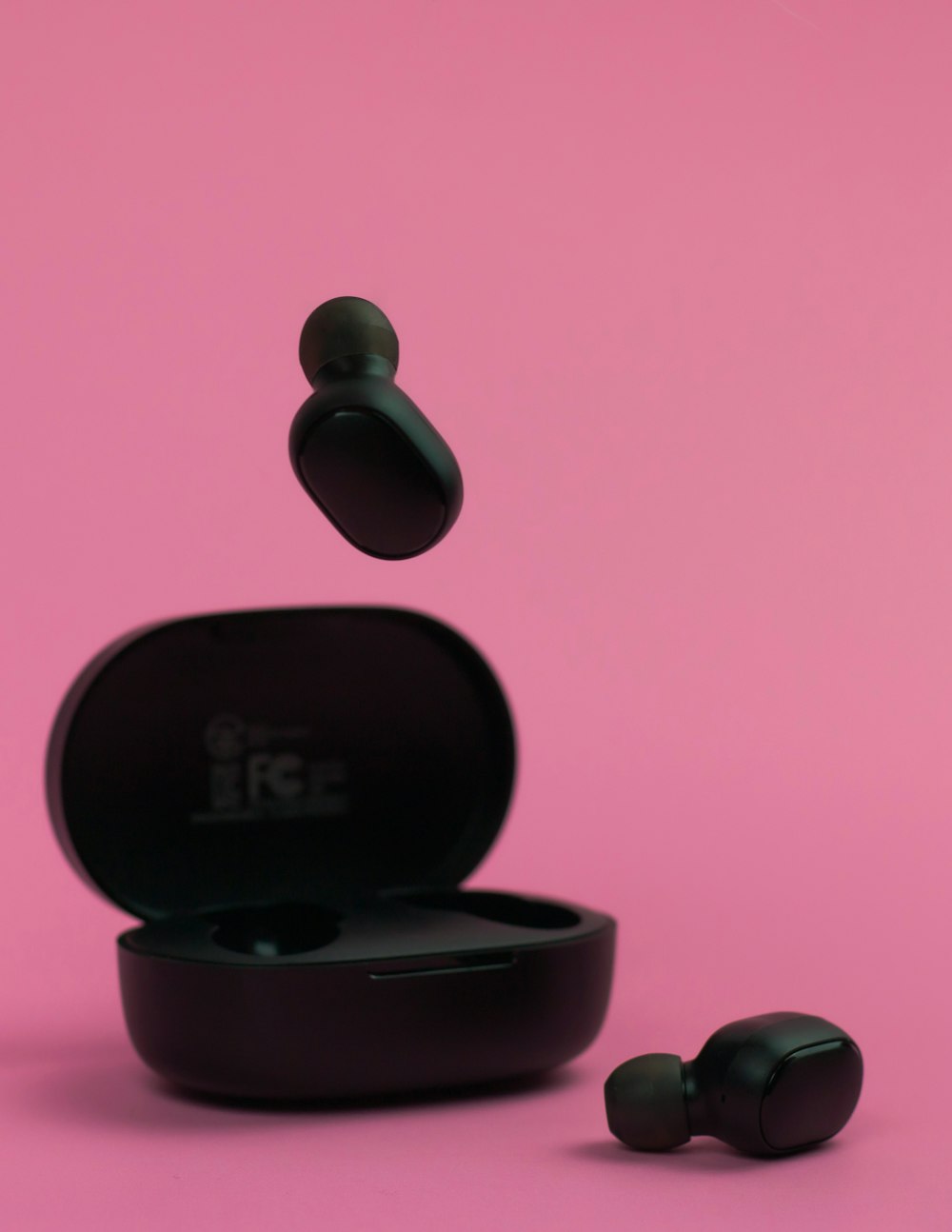 a pair of ear buds floating in the air