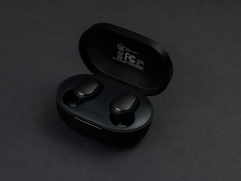 a pair of black earbuds sitting on top of a table