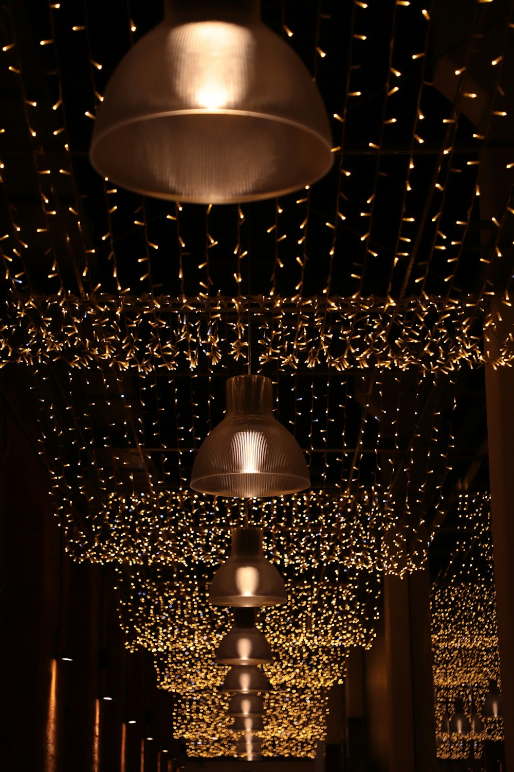 a long hallway with lights hanging from the ceiling