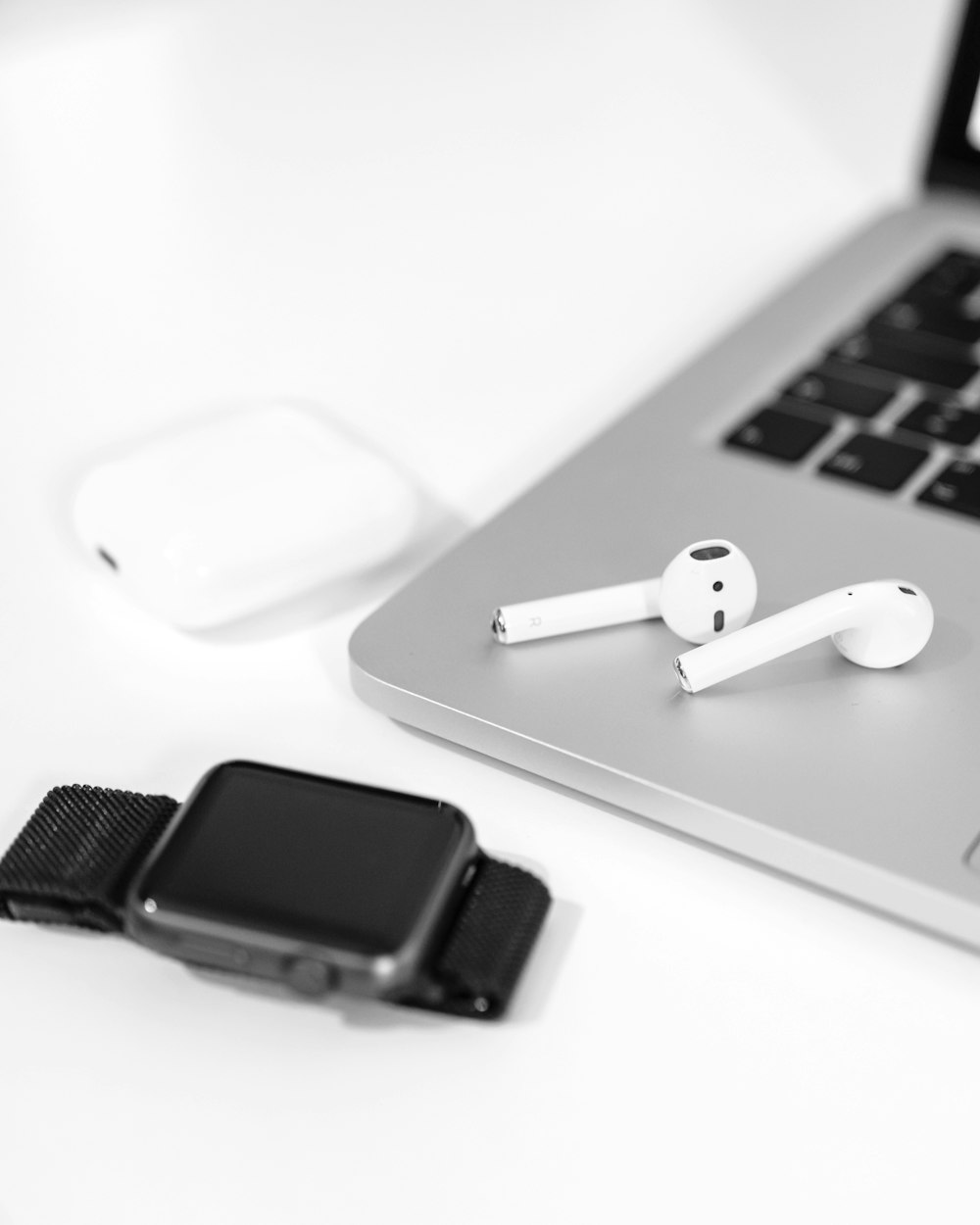 a pair of ear buds sitting on top of a laptop