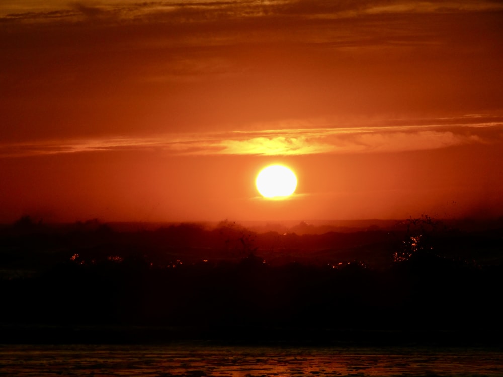 the sun is setting over a body of water