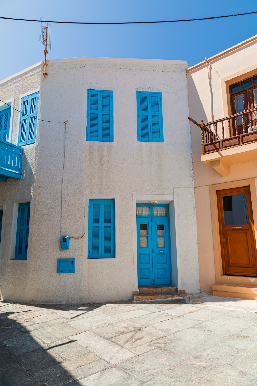 a white building with blue windows and a blue door