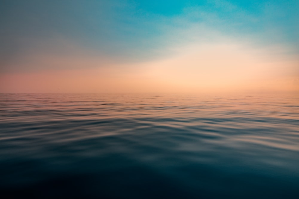 a large body of water sitting under a blue sky