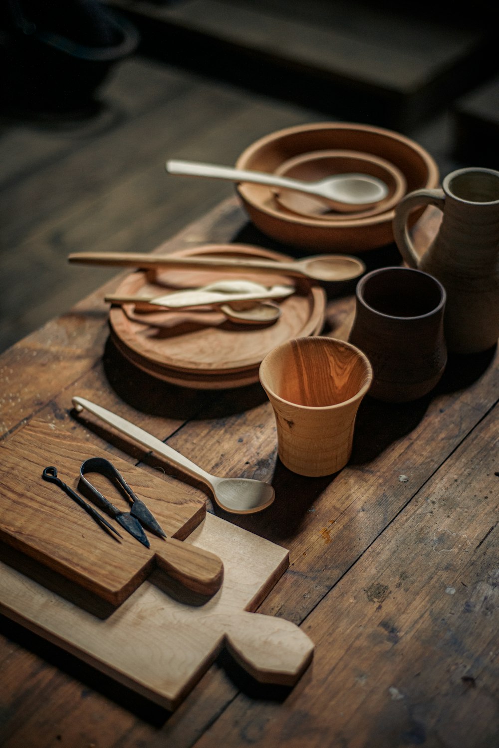 a wooden table topped with lots of wooden utensils