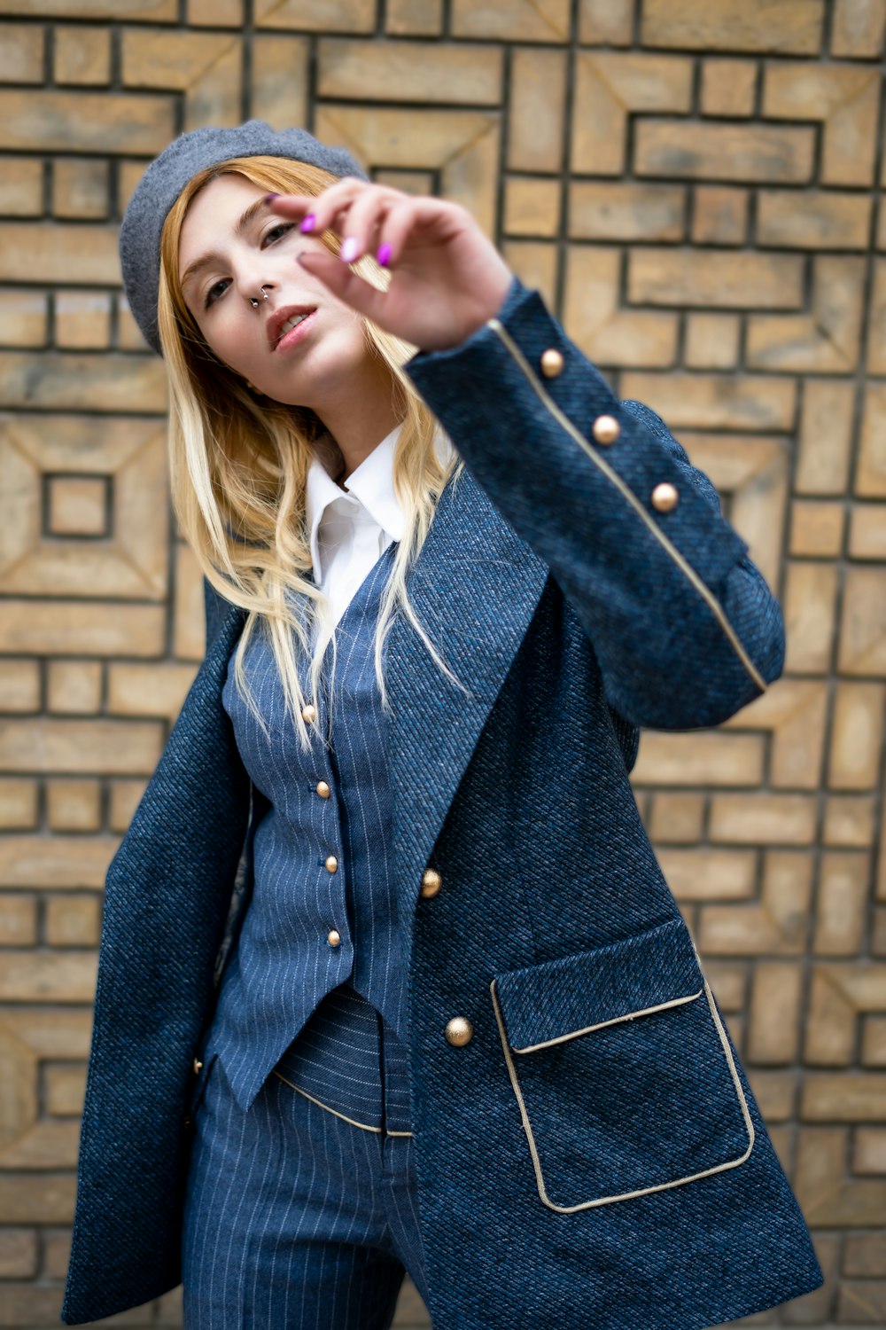 a woman wearing a blue suit and a hat