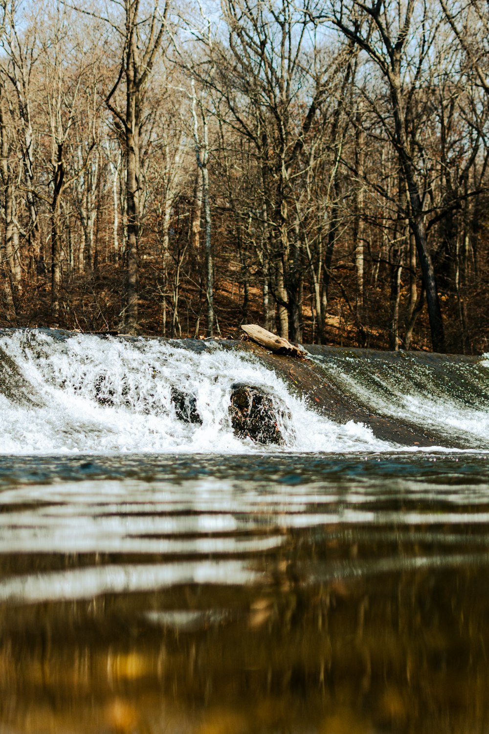 a man riding a surfboard on top of a river