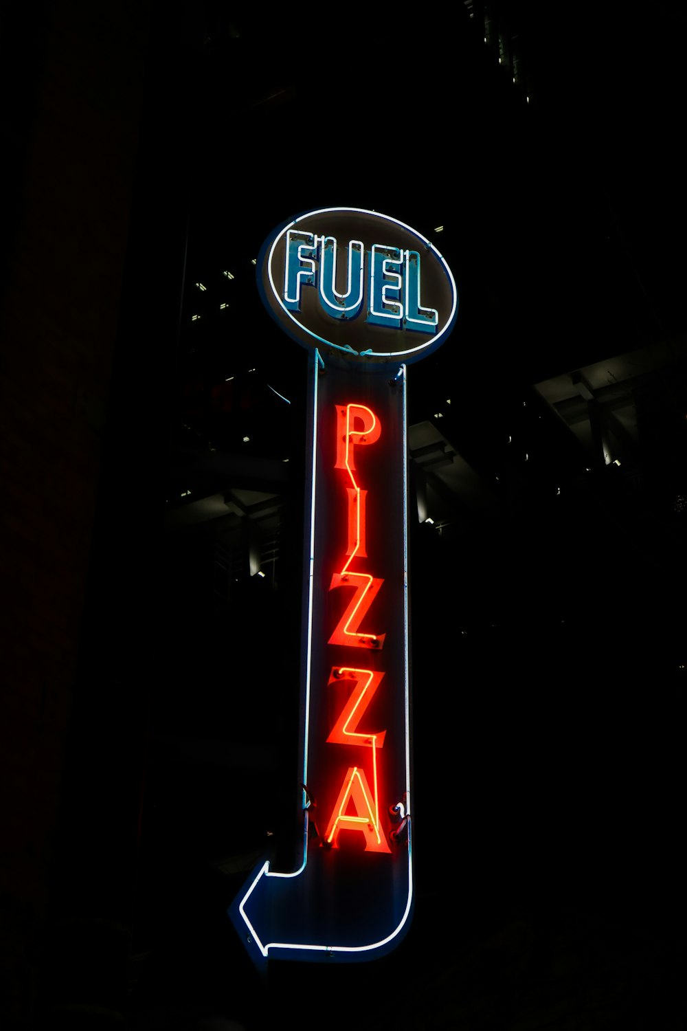 a neon sign for a pizza restaurant in the dark