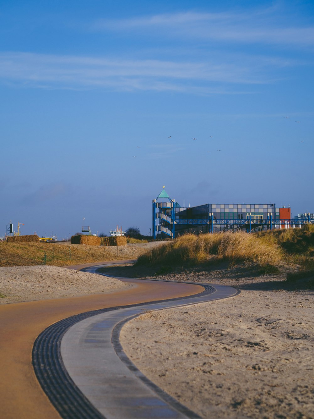 a curved road with a building in the background