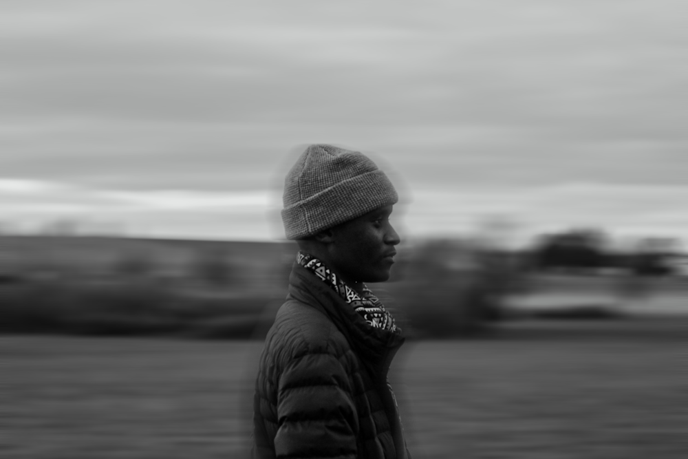 a black and white photo of a man in a beanie