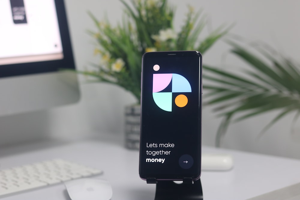 a cell phone sitting on top of a stand on a desk