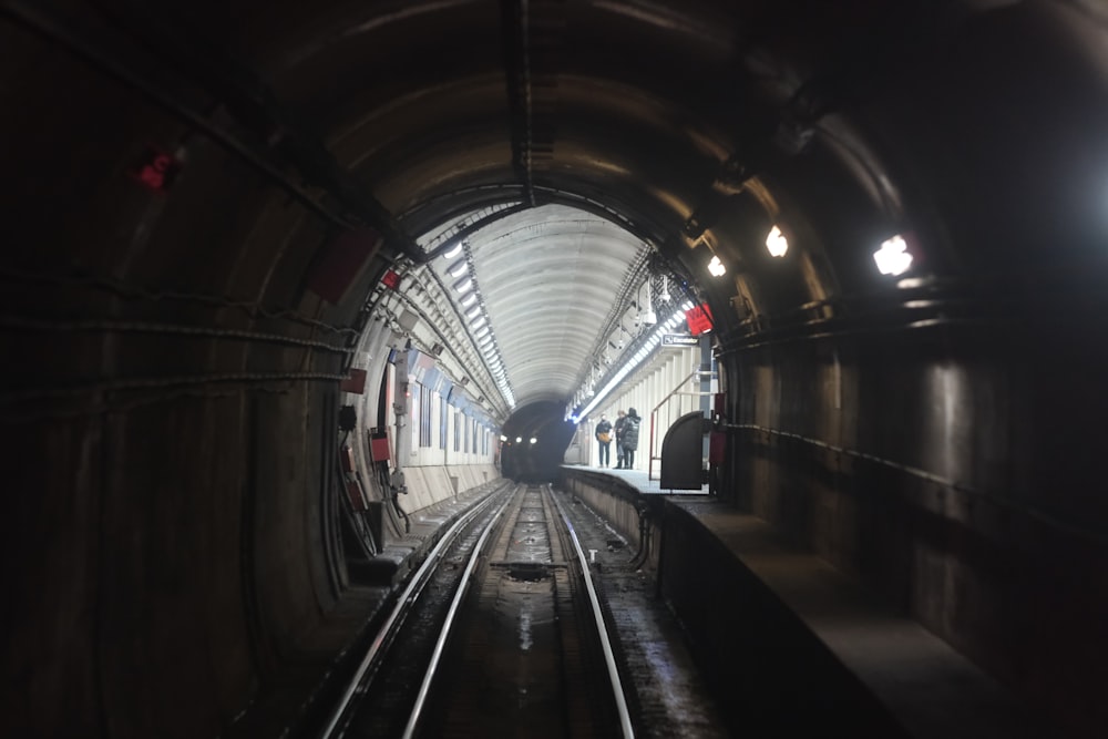 a train traveling down train tracks in a tunnel