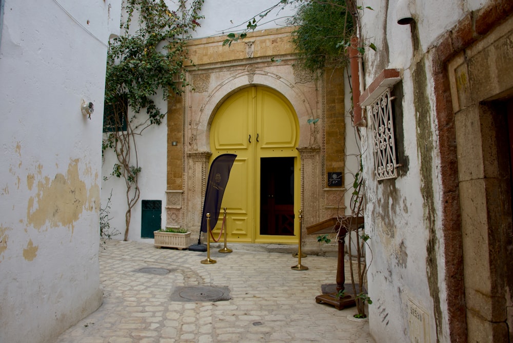a narrow alley way with a yellow door