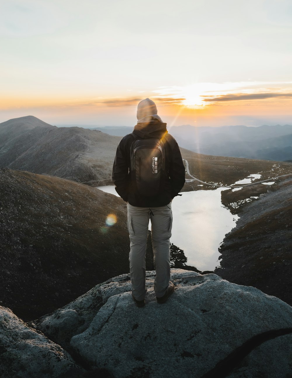 a person standing on top of a mountain overlooking a lake