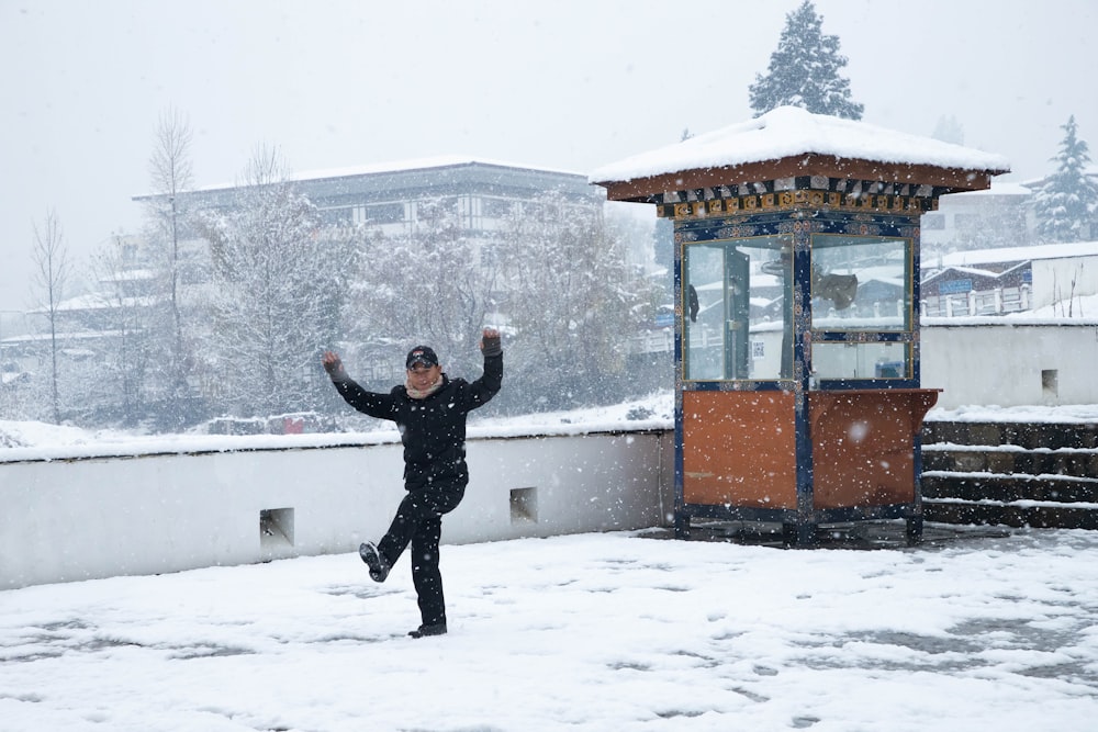Un hombre parado en la nieve con los brazos en el aire
