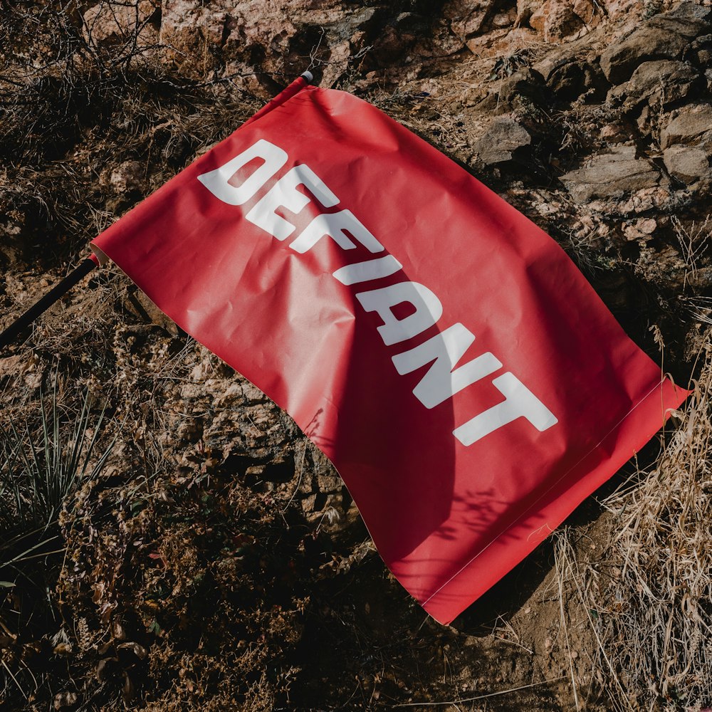 a red flag laying on top of a dirt field