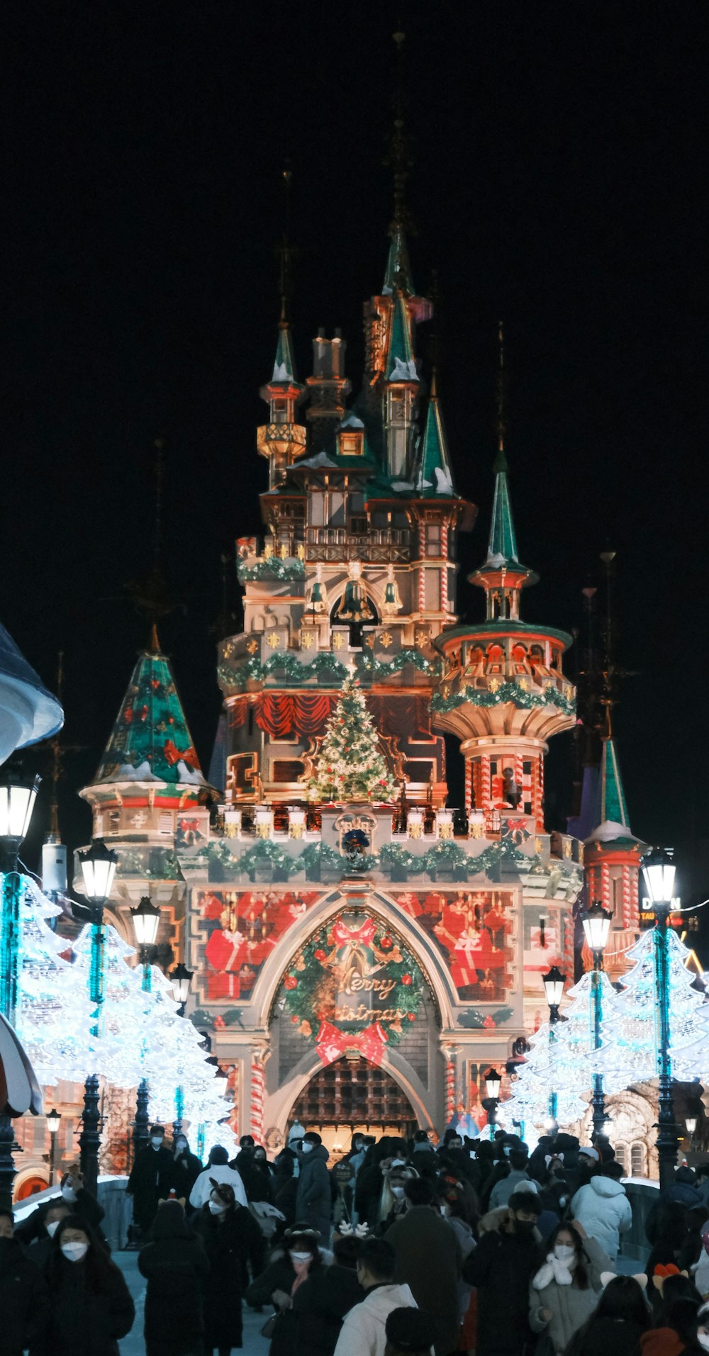 a crowd of people standing in front of a lit up building