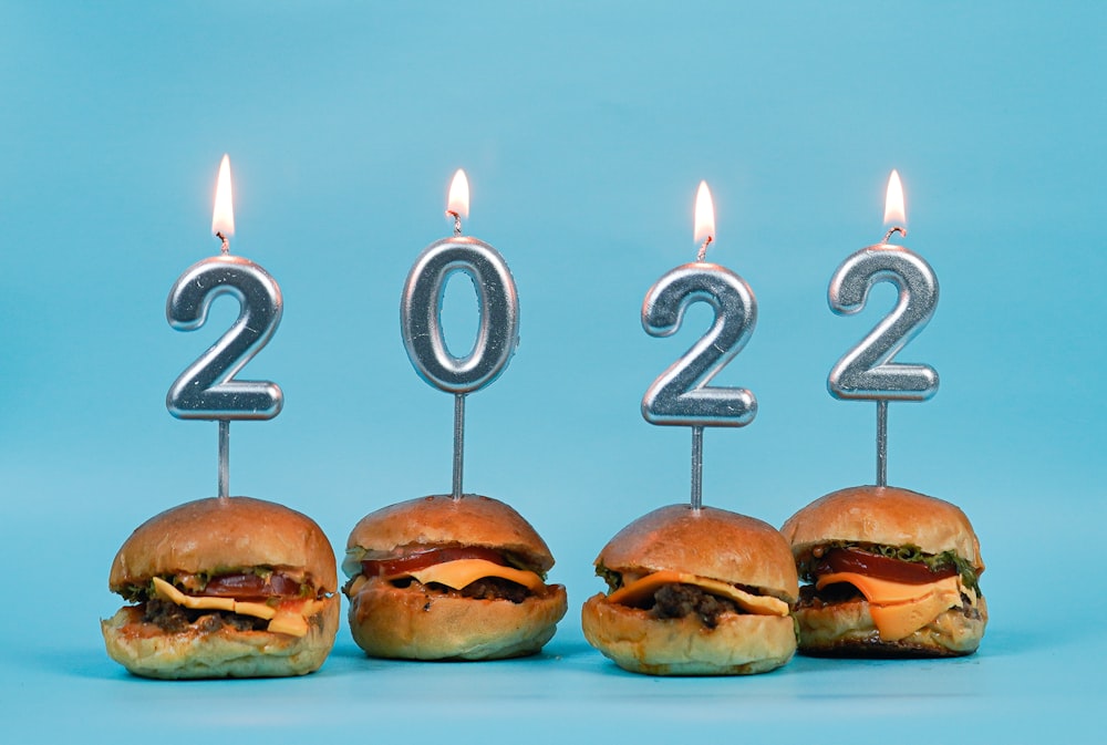 a group of hamburgers with candles in the shape of numbers