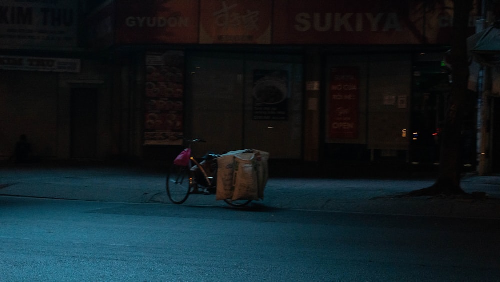 a person riding a bike down a street at night