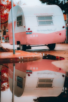 a pink and white trailer parked on the side of a road