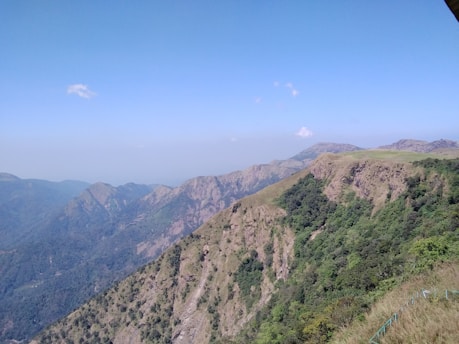 A breathtaking view of lush green mountains under a clear blue sky.