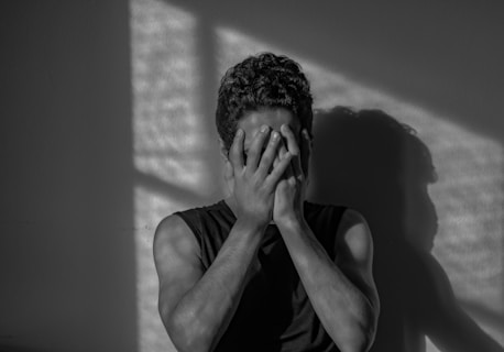 a man covering his face with his hands