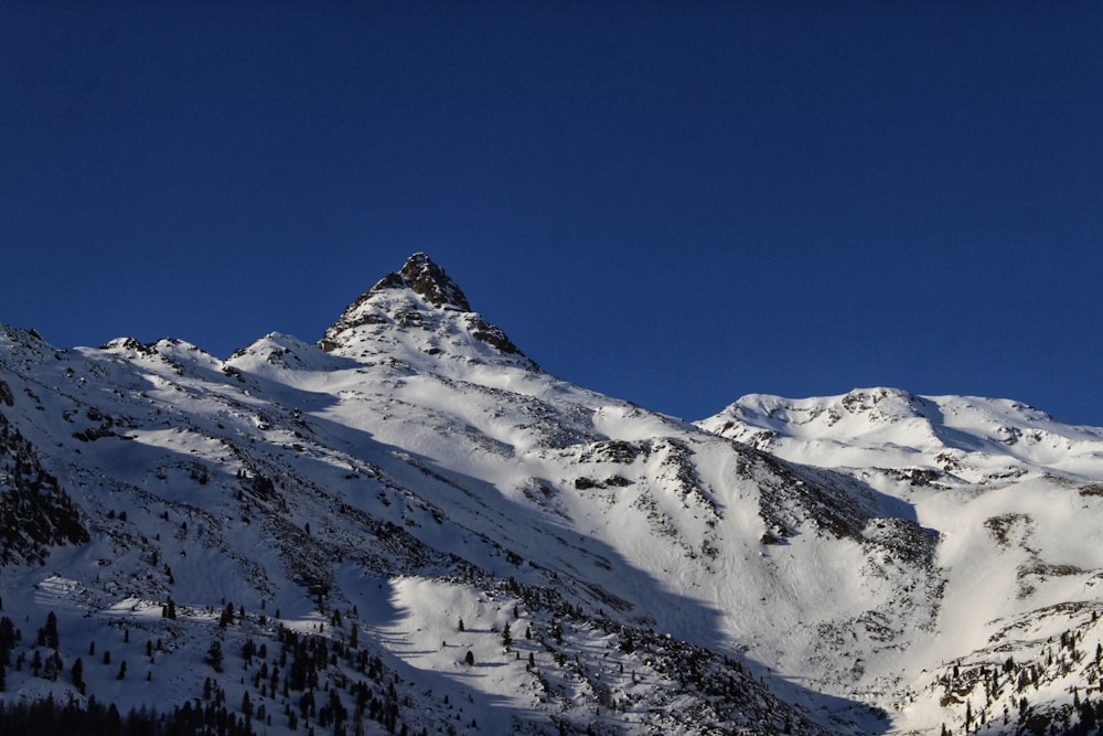 a mountain covered in snow under a blue sky