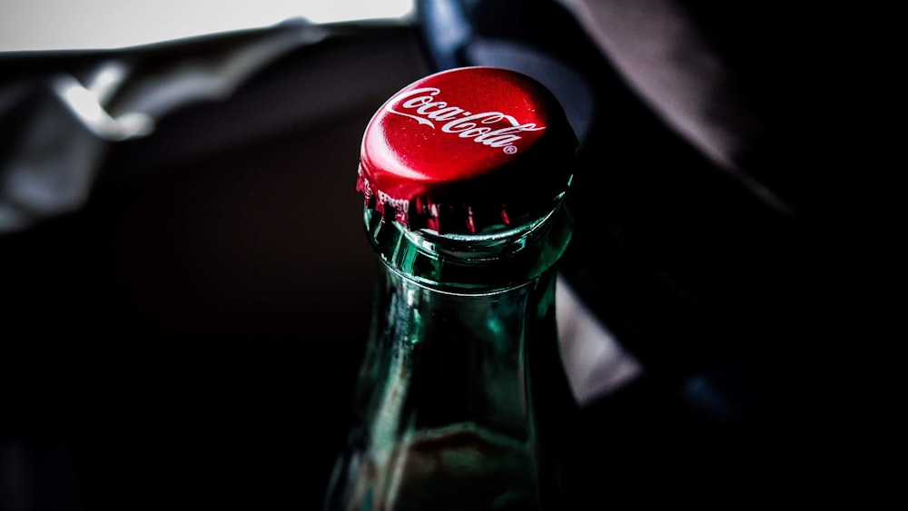 a coca cola bottle with a red cap