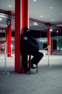 a man sitting on a chair next to a pole