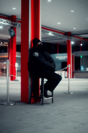 a man sitting on a chair next to a pole