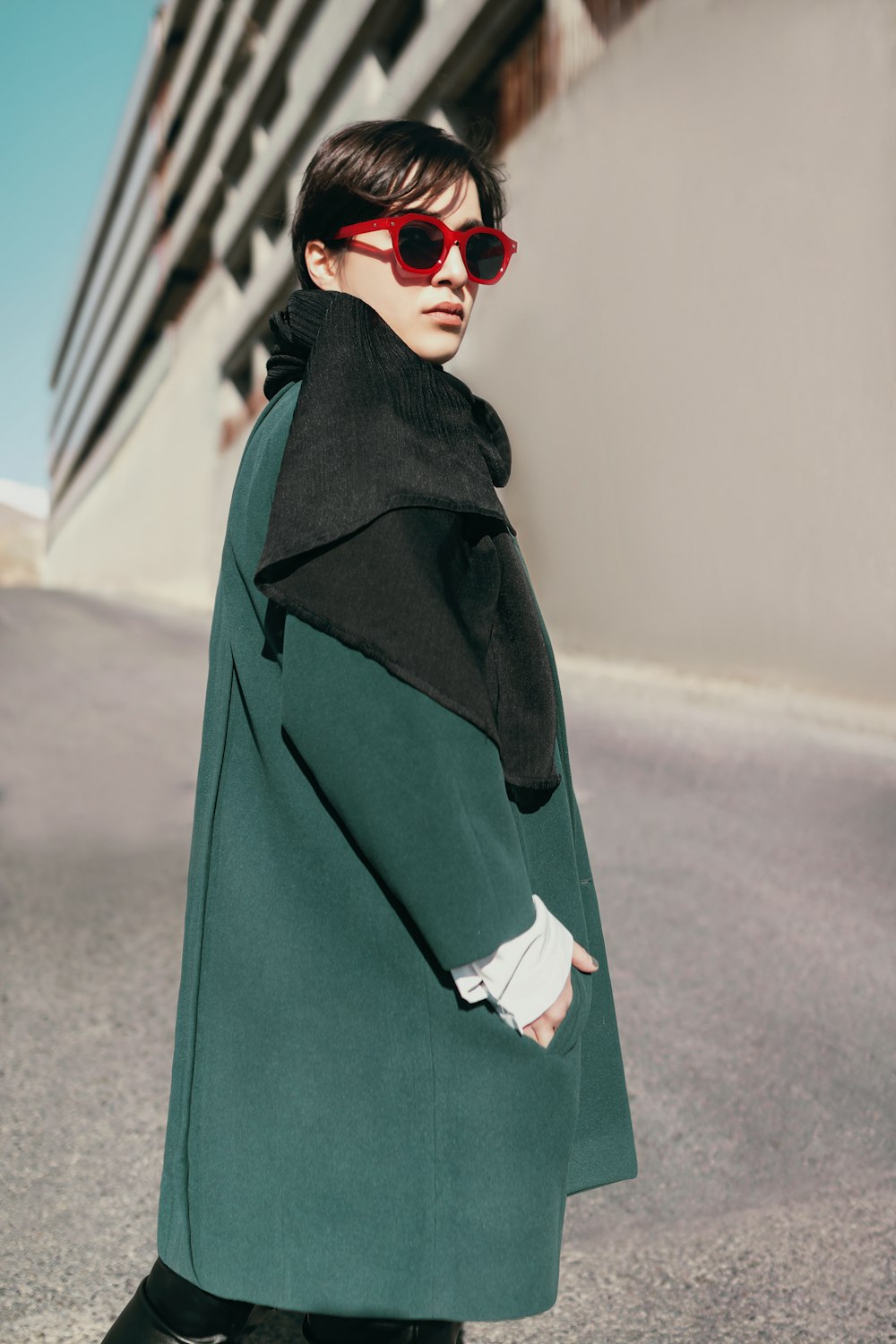 a woman in a green coat and sunglasses